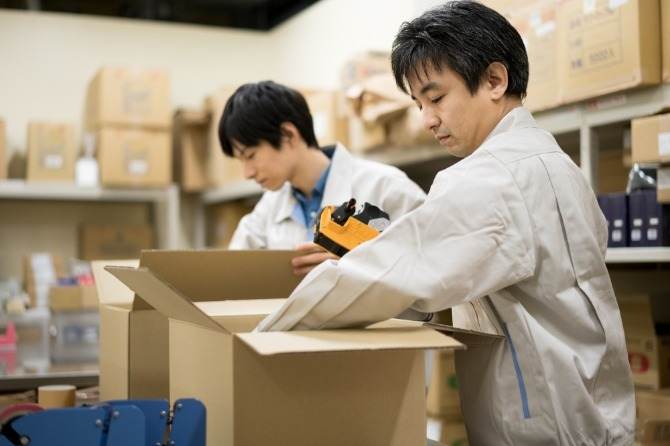 段ボールを開けて商品を取り出し、包装スタッフのところに商品を積みます。